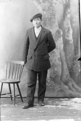 Studioportrett av en mann med sixpencelue.