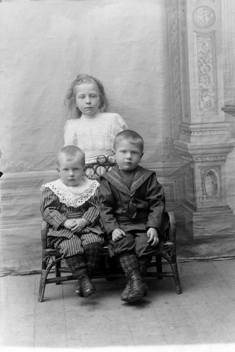 Studioportrett i helfigur av tre barn.