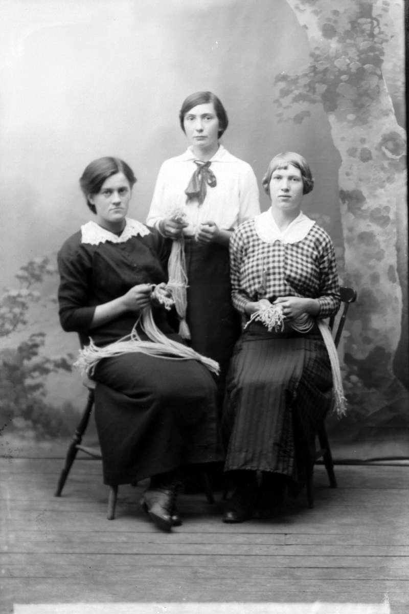 Studioportrett av tre kvinner med snørebunter.