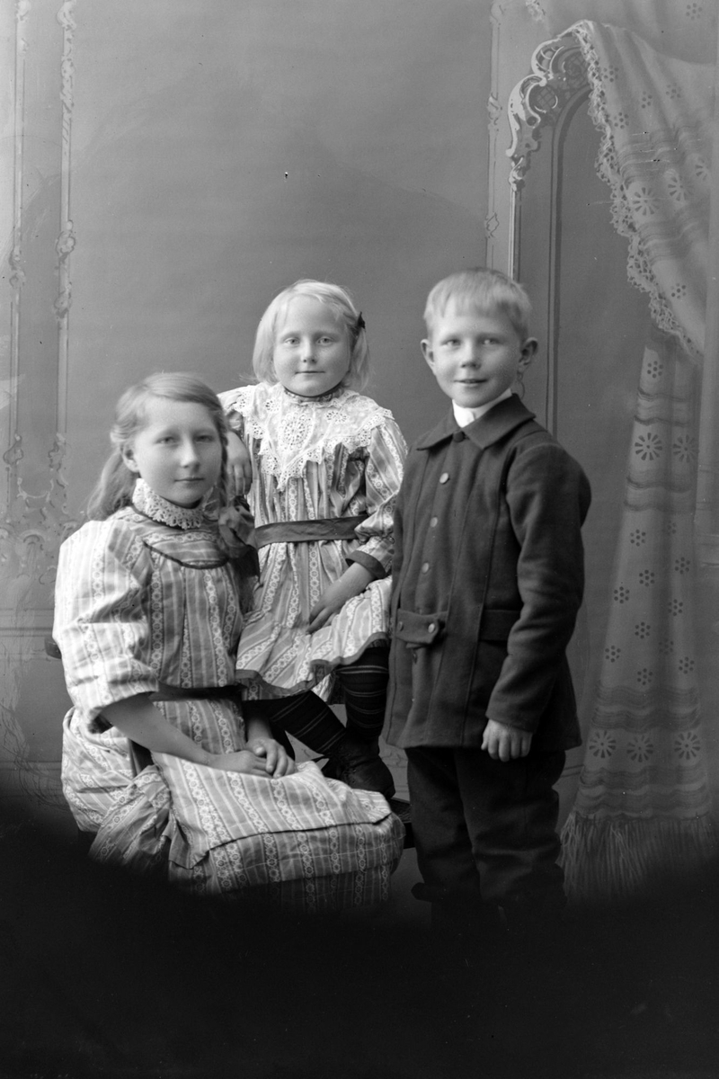 Studioportrett av tre barn.
