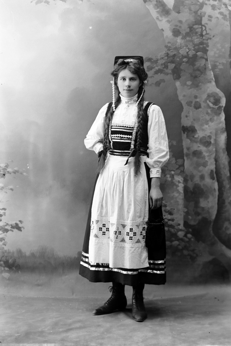 Studioportrett av en kvinne kledd i bunad.