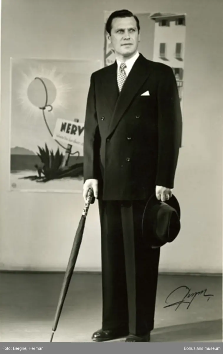 Mannekäng klädd i en mörk kostym med två rader med knappar. Schwartzman & Nordström hade modevisning i Stockholm för sina kunder år 1968