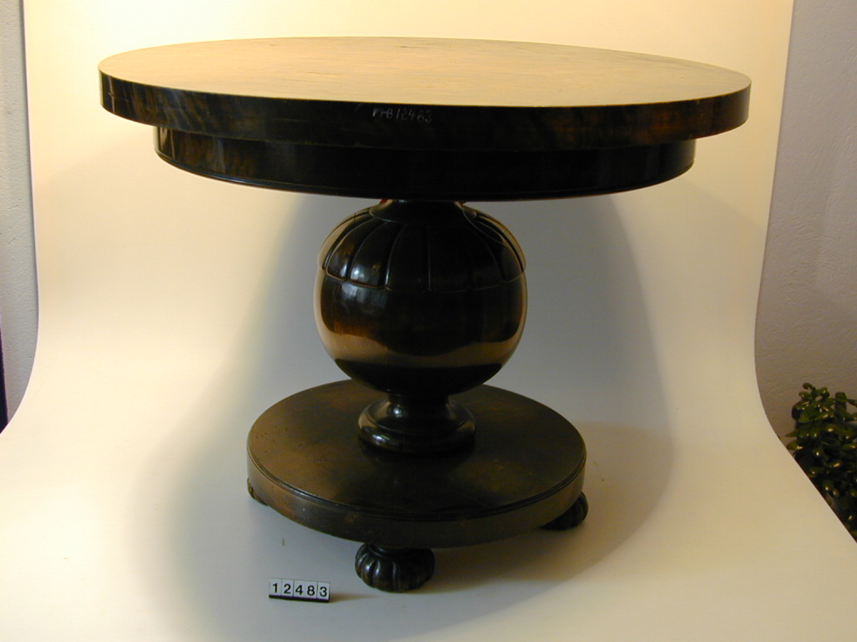 Form: Sirkulær bordflate på kuleformet søyle med stett.

