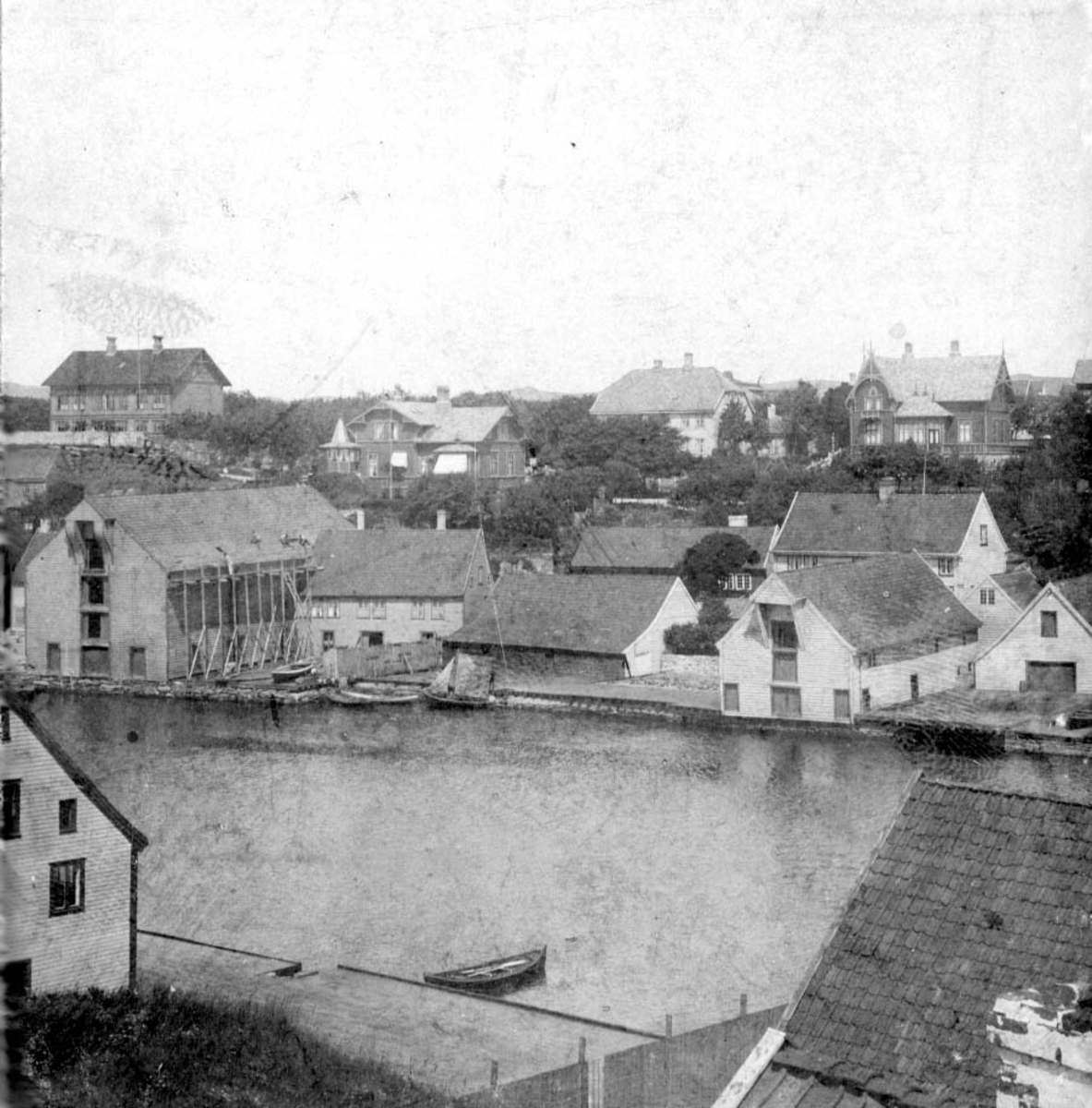 Fra Kronå og Christiansenbryggå i 1890-åra. På det store sjøhuset til venstre er det satt opp et stillas og utføres takarbeid.