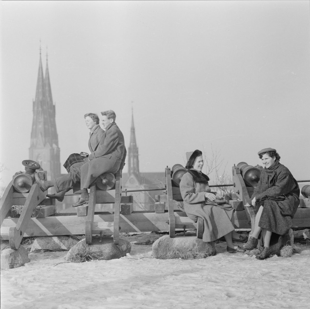 "Solande ungdomar vid Gunillaklockan i snö", Uppsala mars 1957
