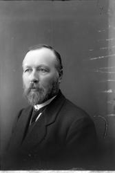 Studioportrett av en mann i halvfigur.