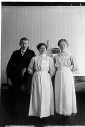 Portrett av en mann og to sykepleiere.