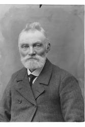 Studioportrett av en eldre mann i halvfigur.