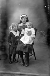 Studioportrett av tre unge jenter i helfigur.