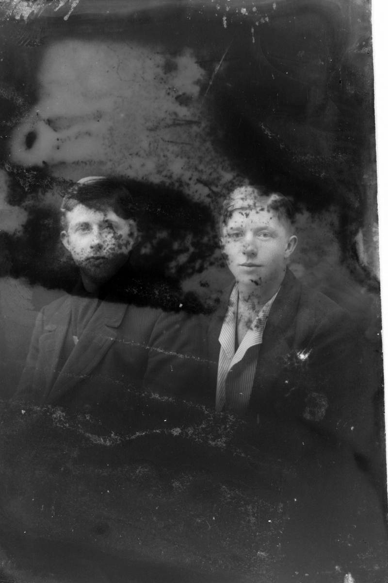 Studioportrett av to gutter i halvfigur. Bildet er skadet.