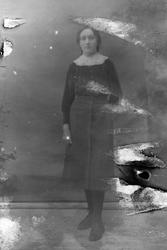 Studioportrett av en ung kvinne i helfigur. Bildet er ganske