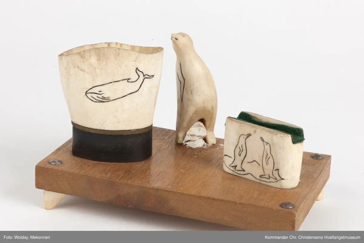 Rektangulær treplate, dekorert med  utskåret pingvin, fyrstikkholder og sigarettholder (ant.) i hvaltann.