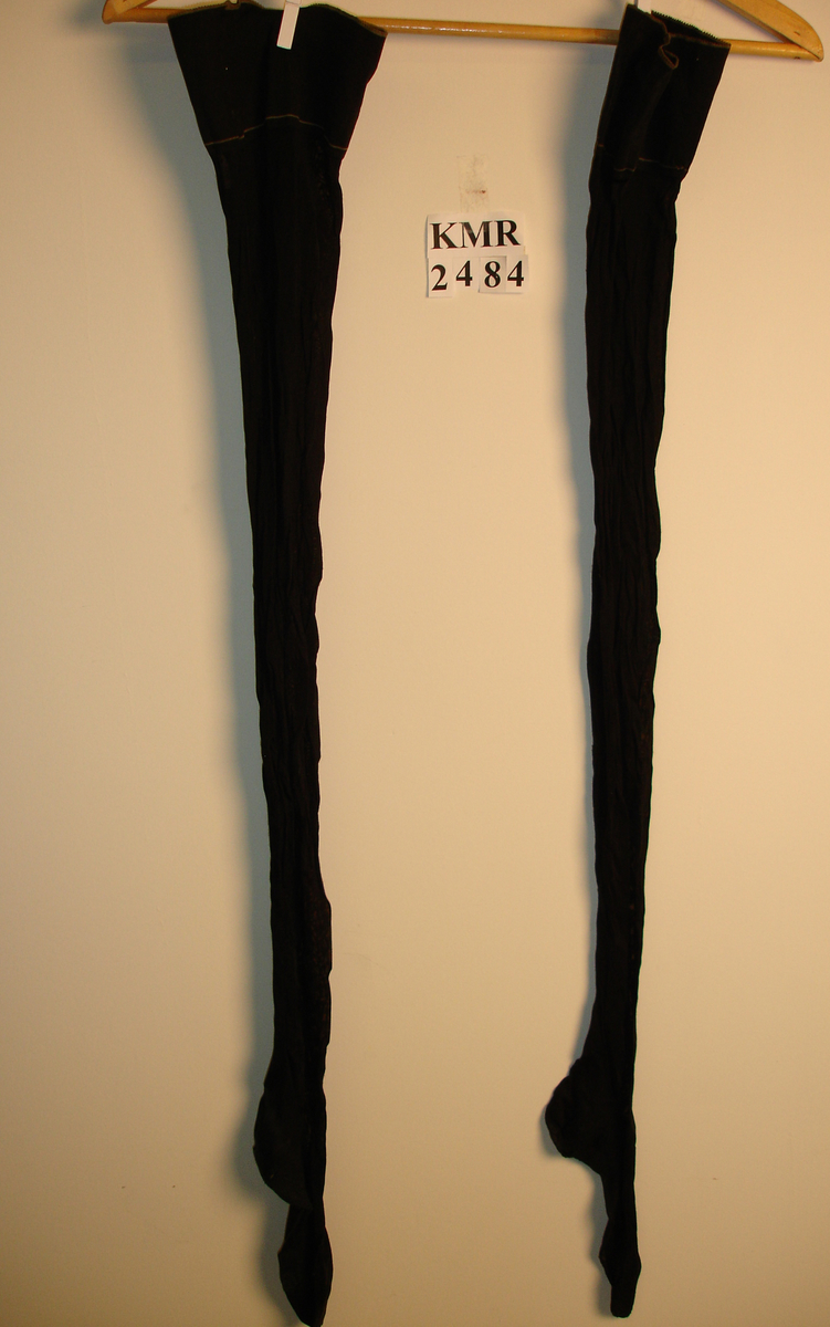 Et par strømper i nylon med bomull som forsterker øverst på strømpene, samt hæl og tå. Lyse brune striper øverst på strømpene.