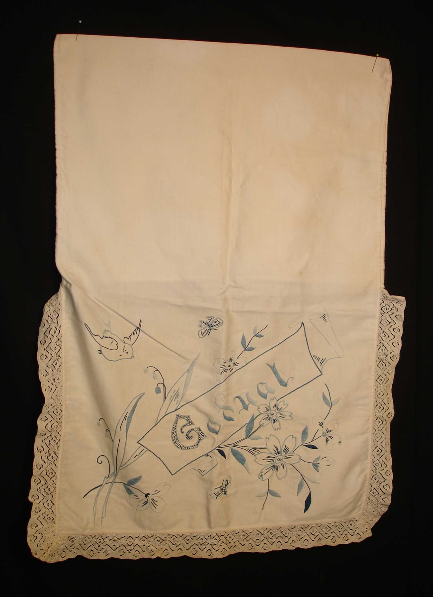 Sengetøypose i hvit bomull med blonderkant rundt, broderi i forskjellige blåfarger, blomstermotiv, fugler, sommerfugler og teksten "Godnat".