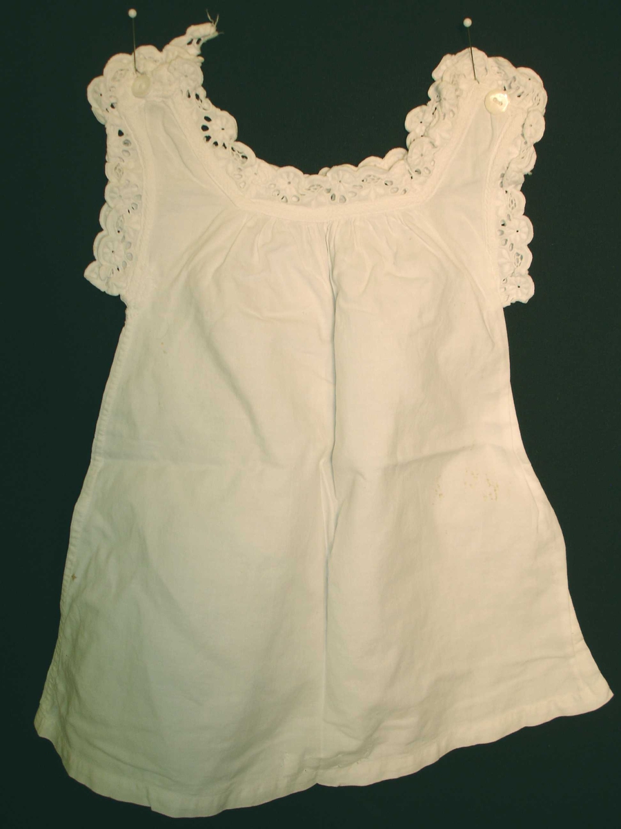 Dukkeklær, Skjorte, kjole i hvit bomullstoff,  blonderkant rundt hals og ermeåpning. 