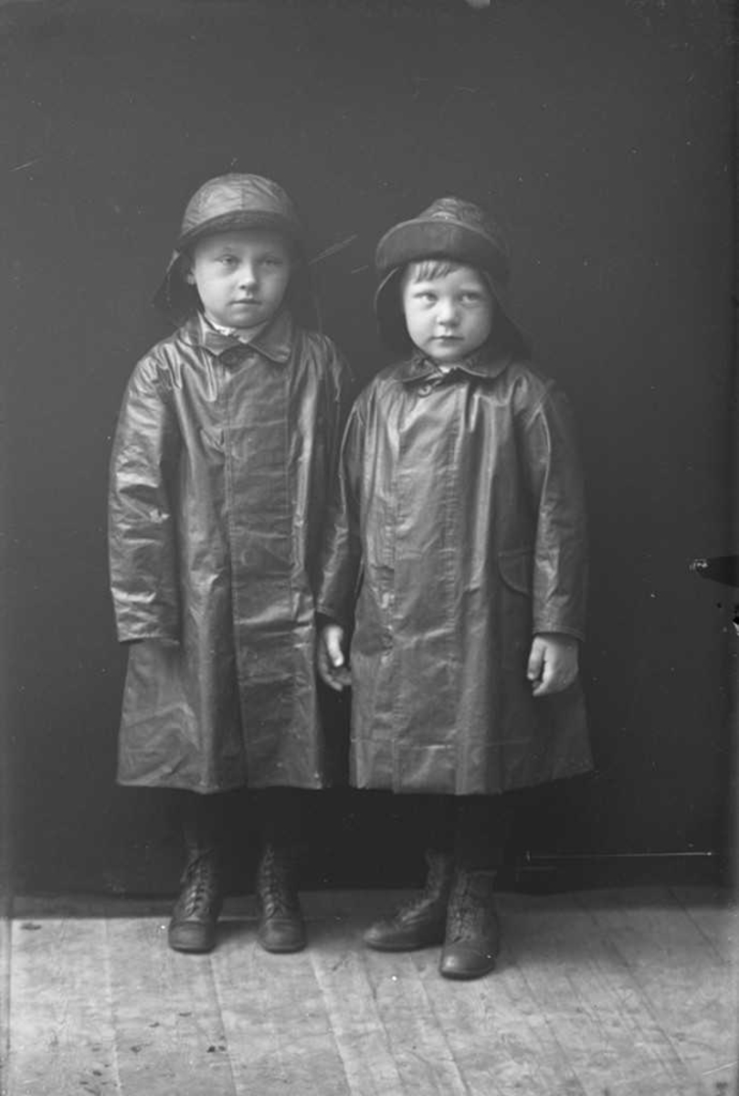 To barn i regnklær. Bildet er tatt i atelieret på Korsnes.