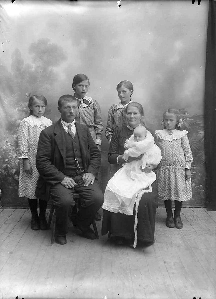 Portrett. Familiebilde.Bak fra venstre:  Paula, Signe, Agnes og Aslaug.
Adolf Albrigtsen Opsahl og Petra Opsahl med dåpsbarnet  Alfhild. Oppsal, Gildeskål.