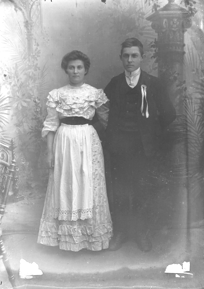 Portrett. Par i 20-åra. Begge står.Bildet er tatt på Reine i Lofoten.