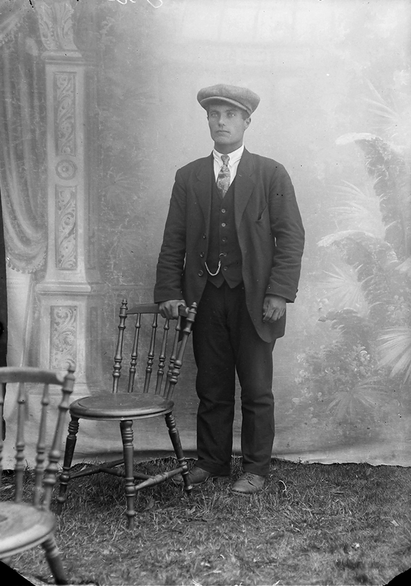 Portrett. Mann, står ved en stol.Bildet er tatt i Sørfold.