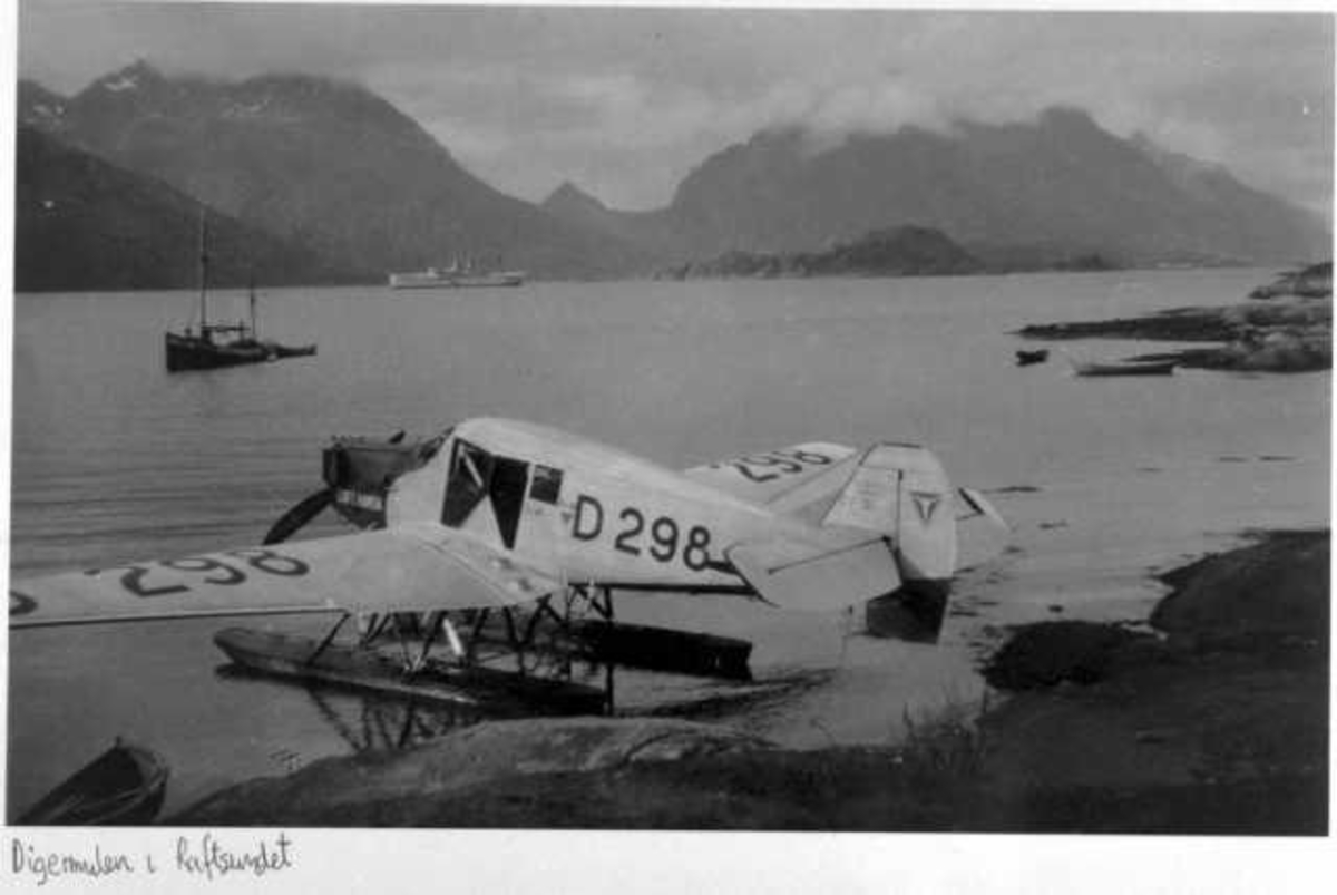 Ett fly ved strandkanten, Junker F13, D-298. Flere mindre og større båter (fartøy) i bakgrunnen.