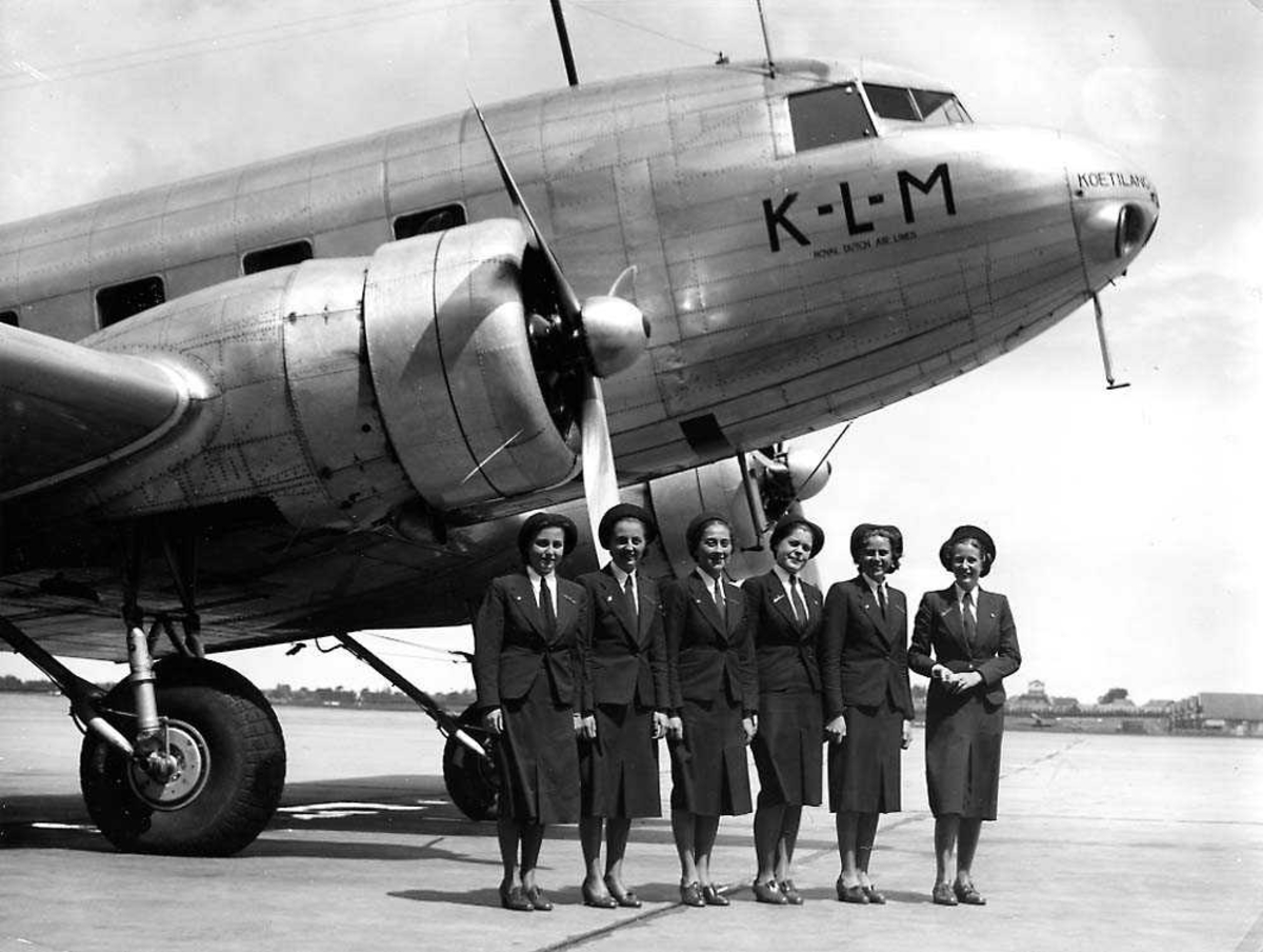 Lufthavn. Frontpartiet av et fly på bakken, Douglas DC-2 PH-AKS fra KLM. Seks flyvertinner står ved flyet.