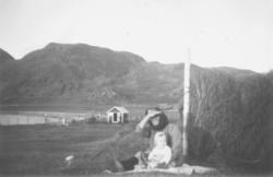Anna Andersen sammen med et barnebarn. De sitter på bakken v
