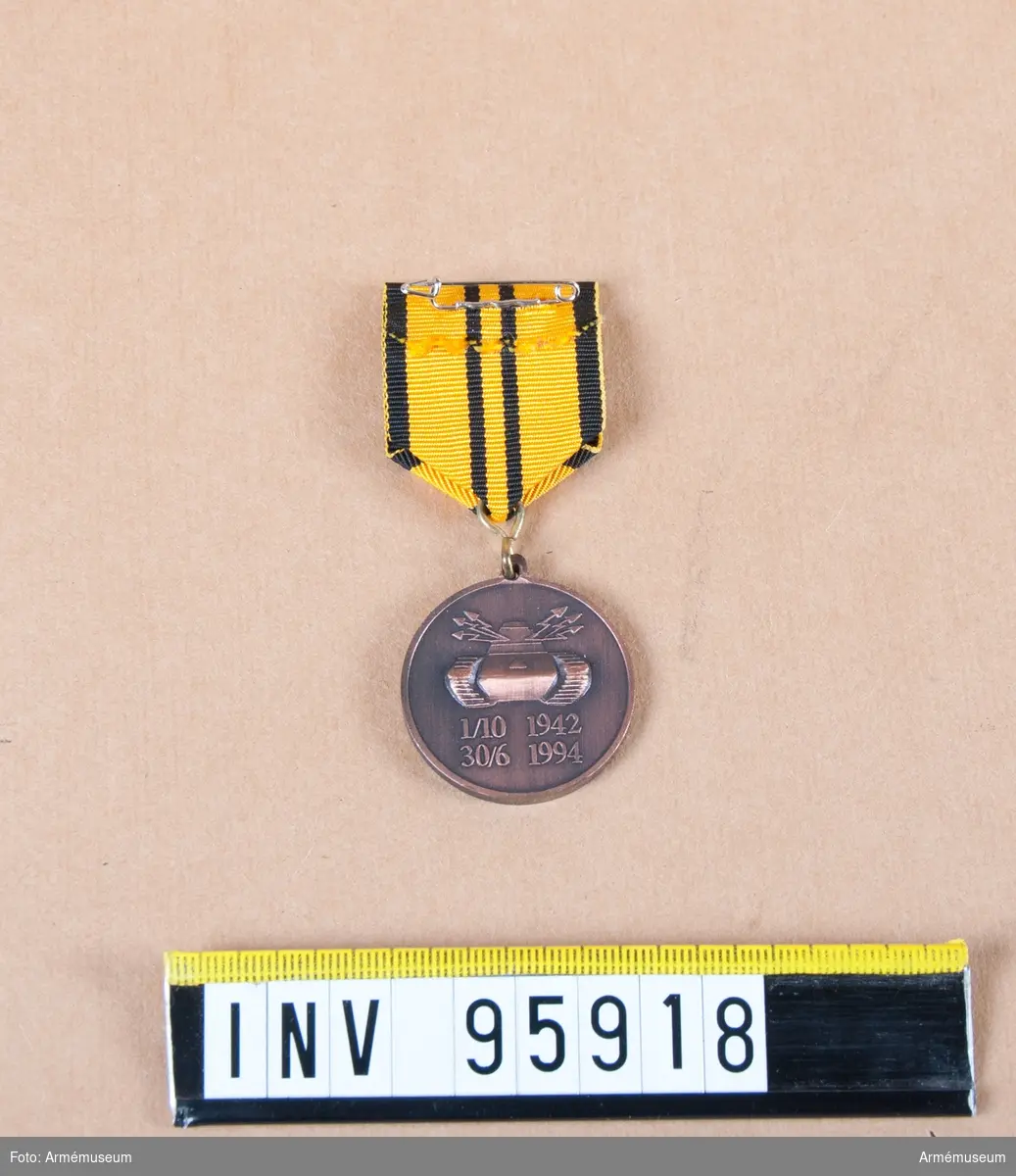 Skånska dragonregementets minnesmedalj 1 (P 2) i brons, 8:e storleken, 1994.

Band: gult med svarta kanter och två svarta ränder på mitten.

Medalj i blå ask klädd med blå sammet och vit siden.