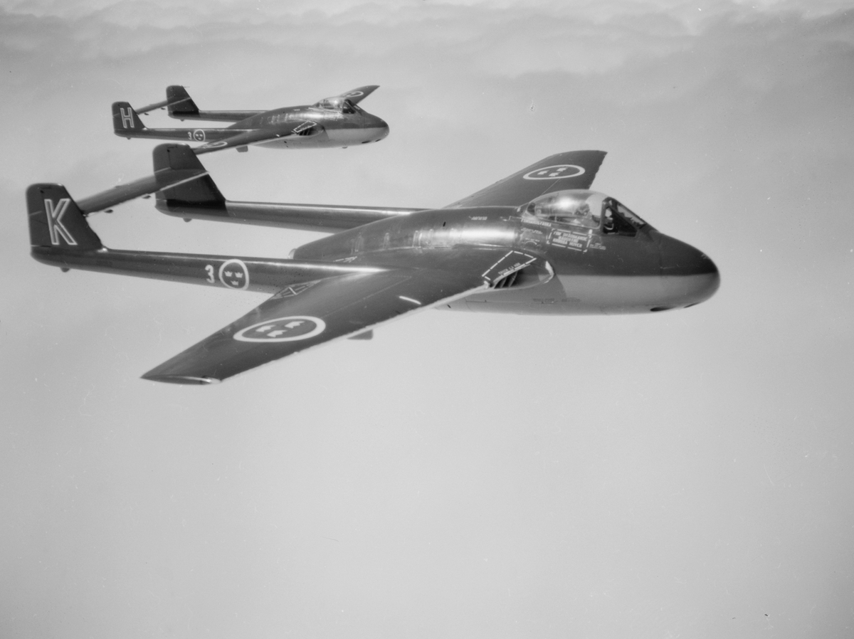 Två stycken flygplan J 28 från F 3 Malmen flyger i rote. Vy från sidan.