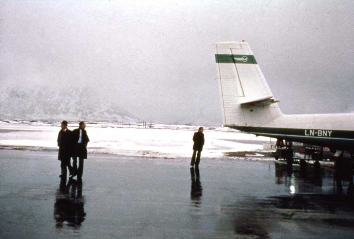 Lufthavn/flyplass. Svolvær/Helle. Et fly, LNBNY, DHC-6-300 Twin Otter fra Widerøe. Passasjerer på tarmac forlater flyet på vei til terminalbygget.