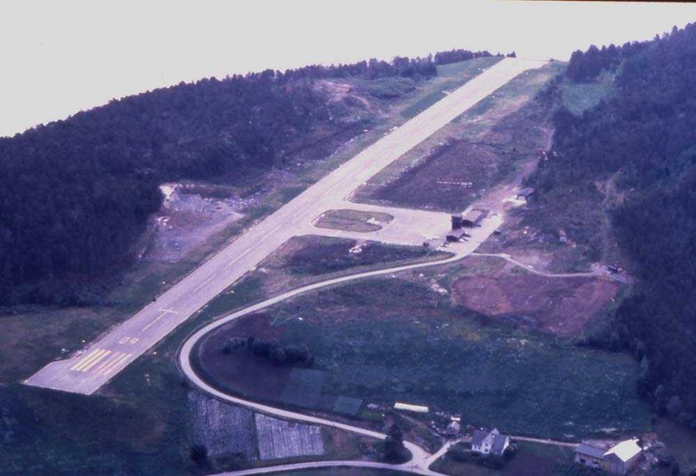 Lufthavn/flyplass. Sandane/Anda. Et fly, DHC-6-300 Twin Otter fra Widerøe passerer over flyplassen for sirkling bane (runway) 27.