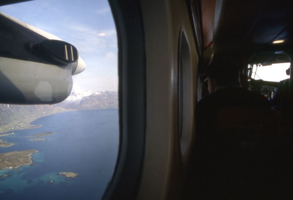 Luftfoto. Gjennom kabinvinduet på en DHC-6-300 Twin Otter fra Widerøe kan en se kystlandskapet med fjord og fjell.