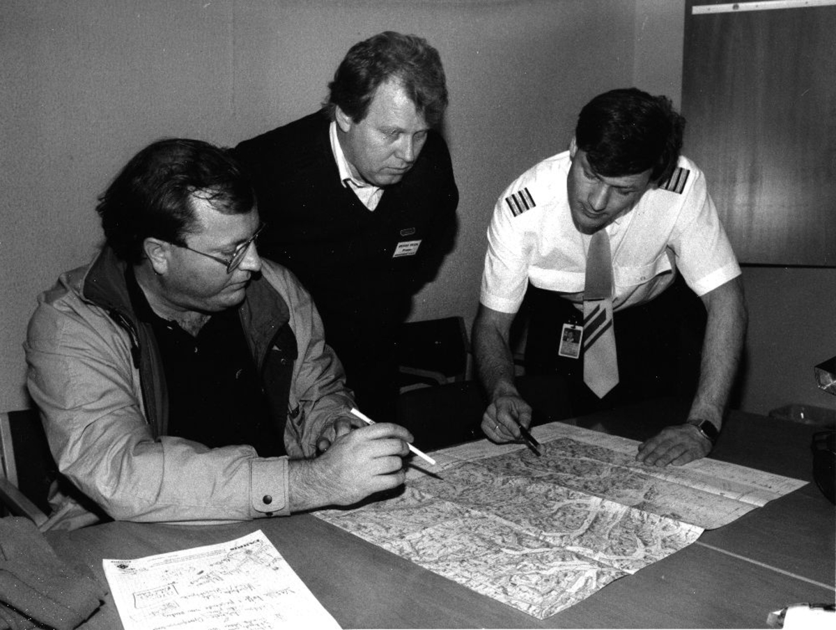 Landskap. Tre personer fra Braathens SAFE studerer et kart  under  "Øvelse Delta"