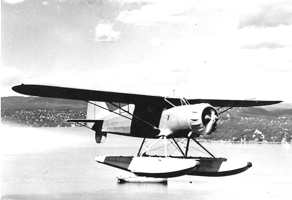 Luftfoto, ett fly, Hønningstad C5          Polar ser no 1., like over havflata. Sjøfly.   Bebyggelse bak.