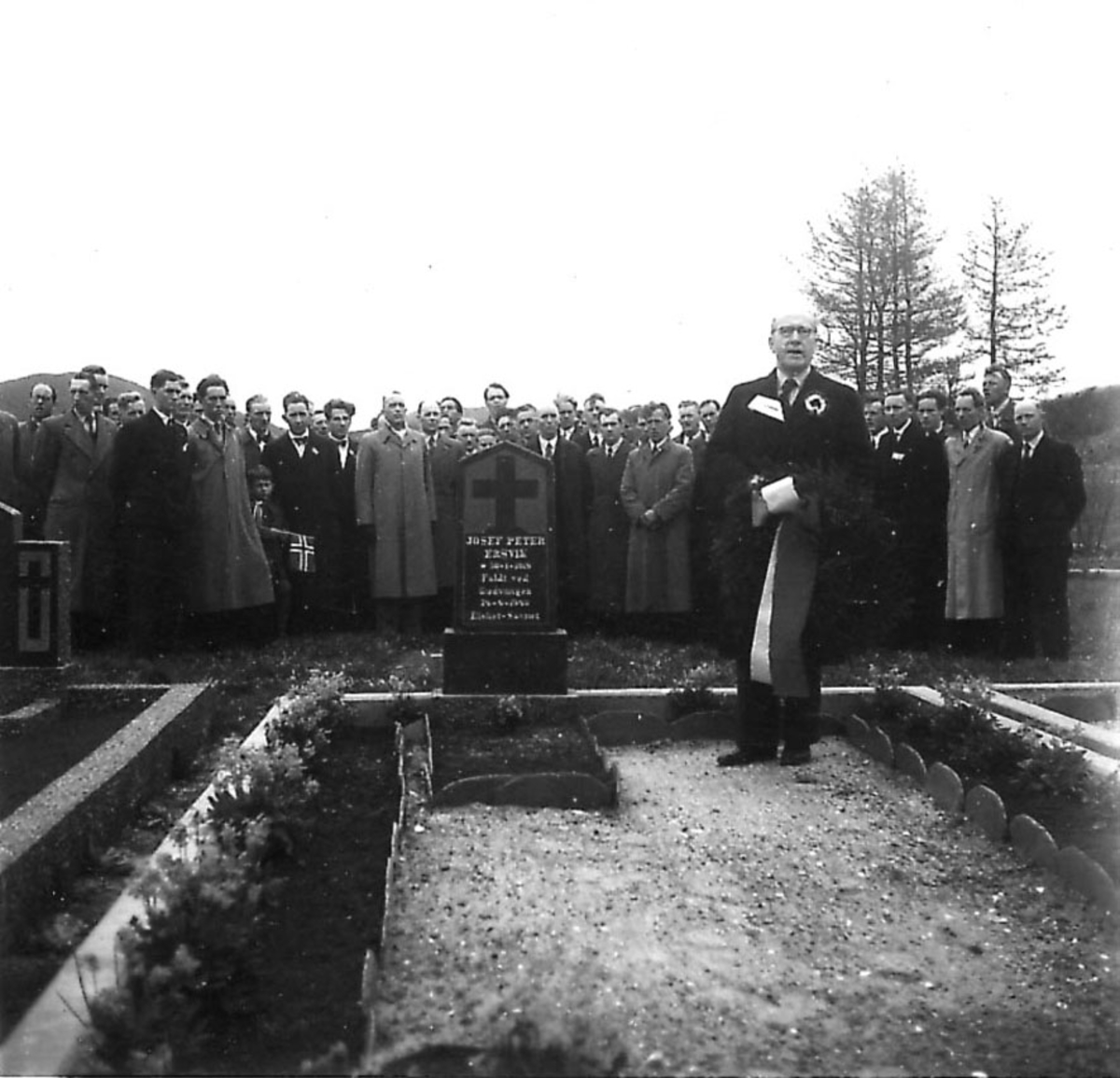 Frigjøringsdagene i Bodø etter krigen 1940 - 1945. Minnestund ved graven til Josef Peter Ersvik. Mange personer, En foran med krans.