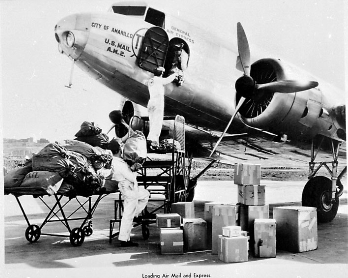 1 fly på bakken.Douglas DC-2 fra TWA. 3 personer laster post og gods ombord i flyet.