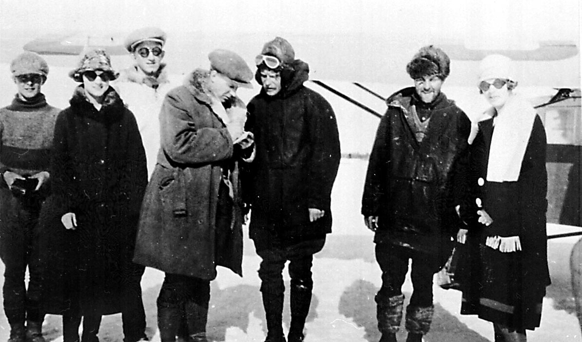 Portrett, flere personer ved 1 fly, Fokker Universal, G-CAFU fra Western Canada Airways.
Bildet tatt ved Hudson Bay airlift i 1927. Bernt Balchen snakker med noen reportere.