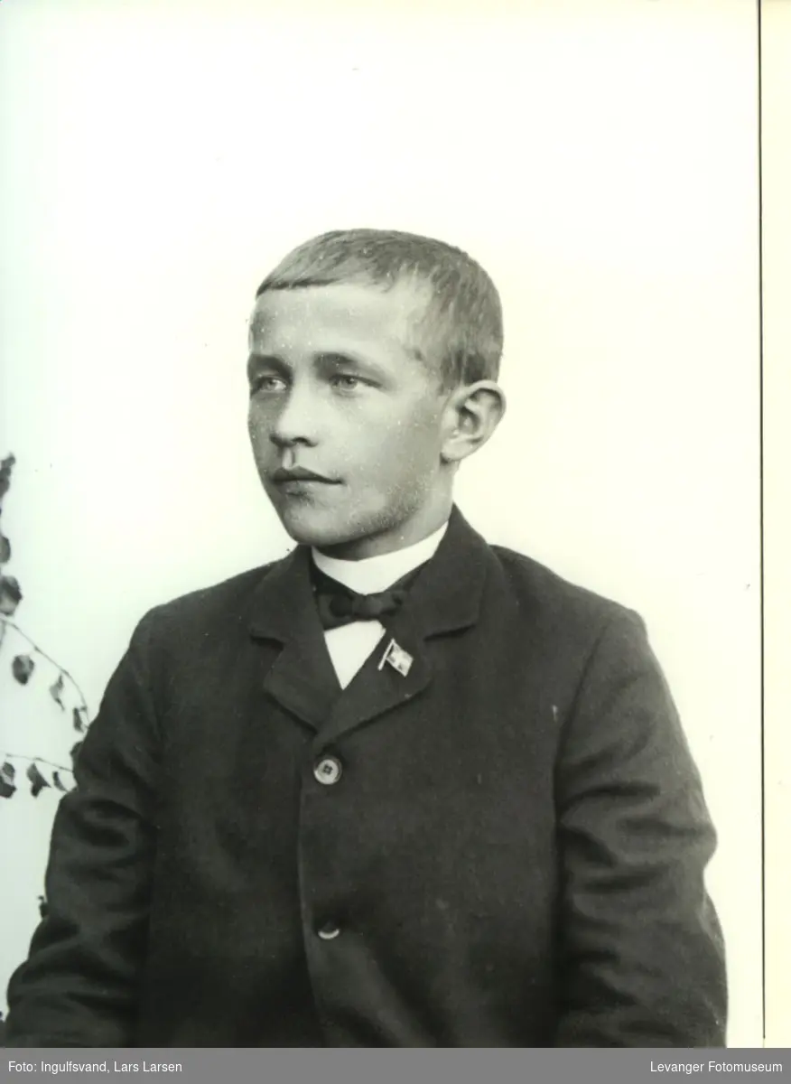 Portrett av gutt med et lite flagg på jakkeoppslaget.