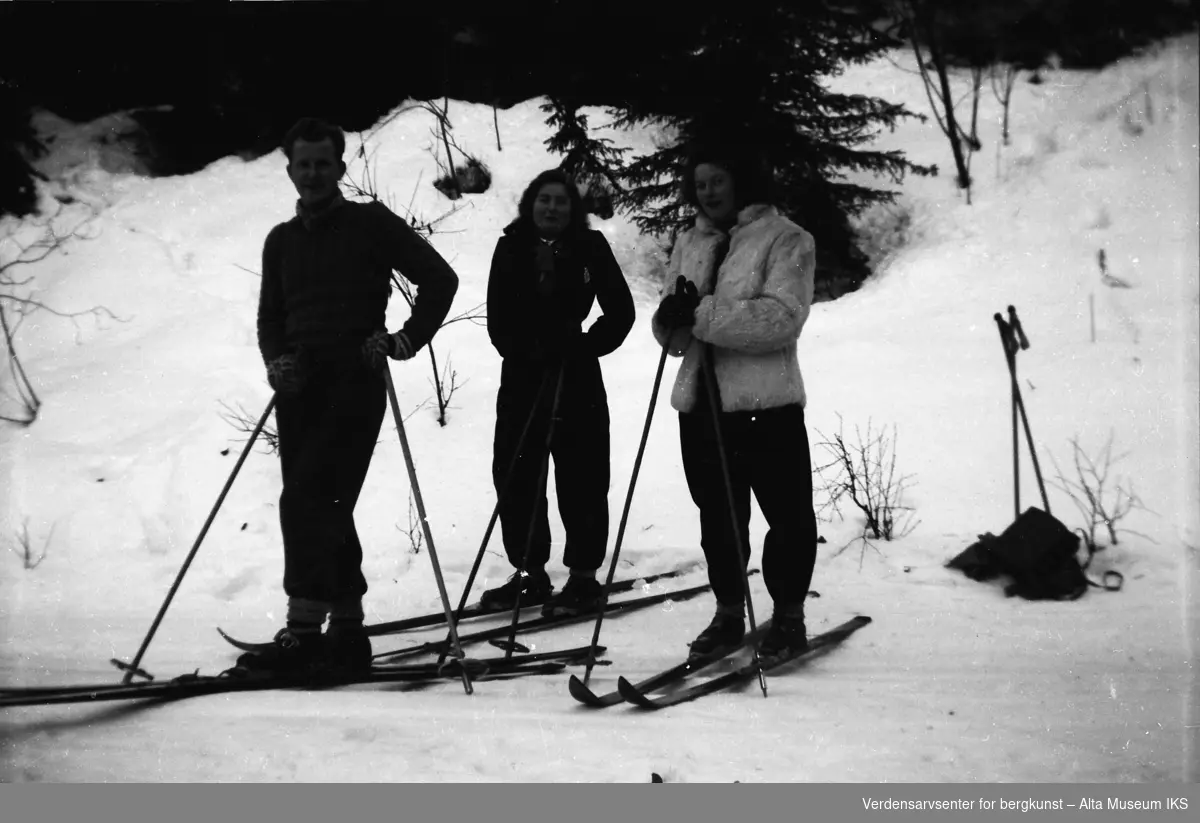 Mann og to kvinner på skitur tar seg en pause midt i skiløypa.
