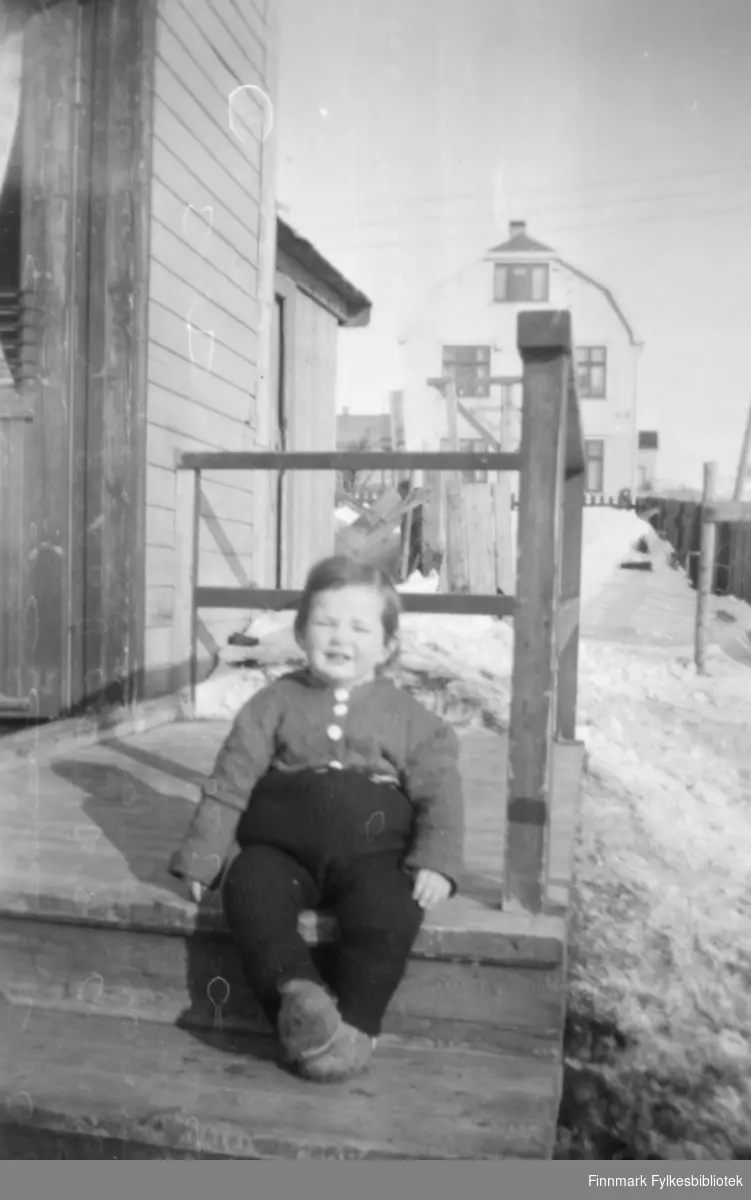 Torill Ebeltoft på trappa hjemme hos bestemor og bestefar Kvam i Slettengata, ca. 1952. I bakgrunnen ser vi andre boliger i området