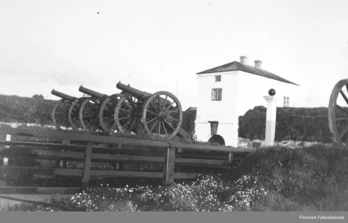 Bildet viser Vardøhus festning. Det hvite bygget er Port med portloft. Foran står 3 stk Næs kanoner, sannsynligvis brukt som saluttkanoner.