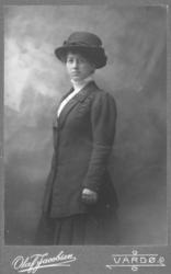 Portrett av en ukjent kvinne tatt i et fotoatelier. Hun er k