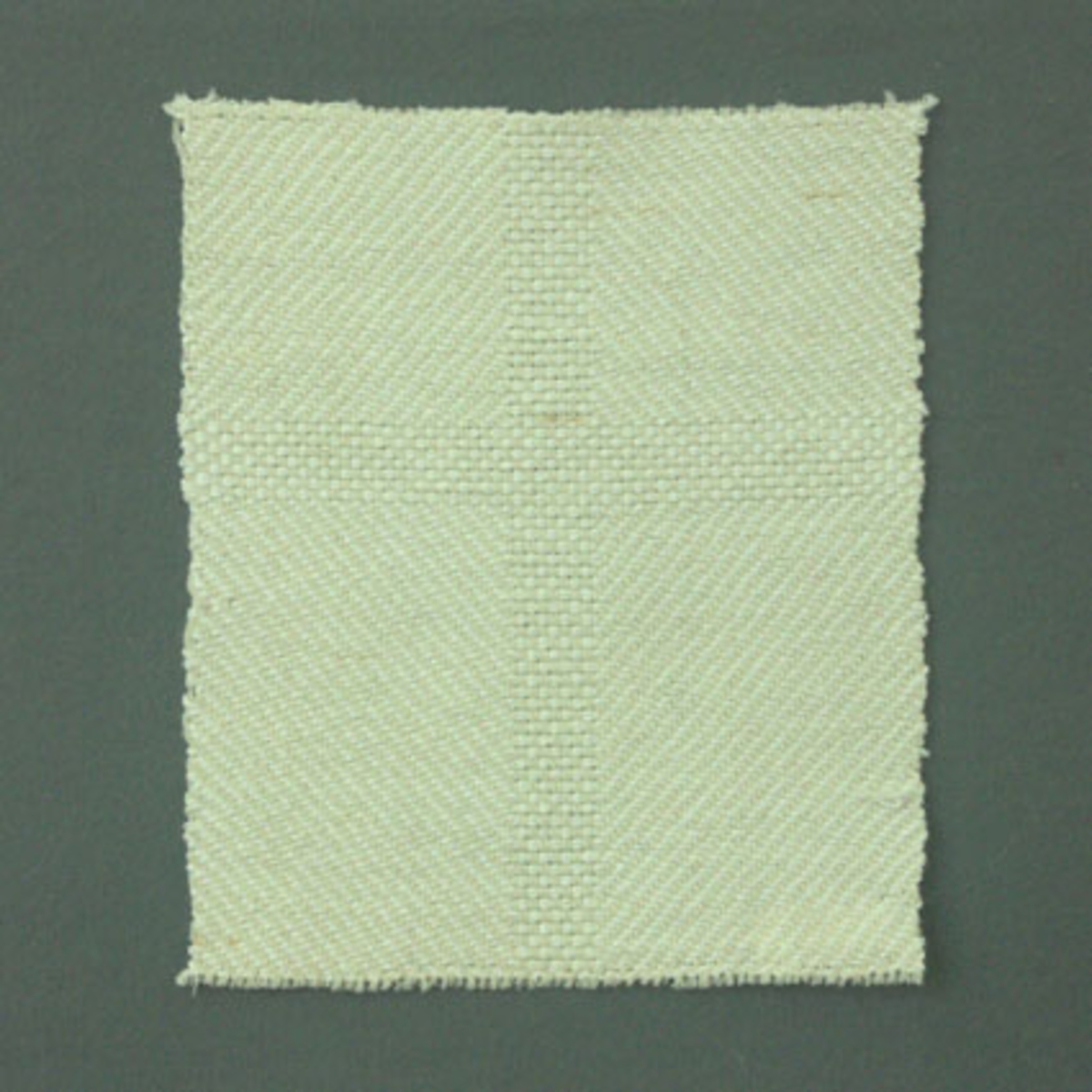 Prov till kyrklig textil enligt tidigare inventering, vävt i kypert och panama med ullgarn i varp och cottolin i inslag.