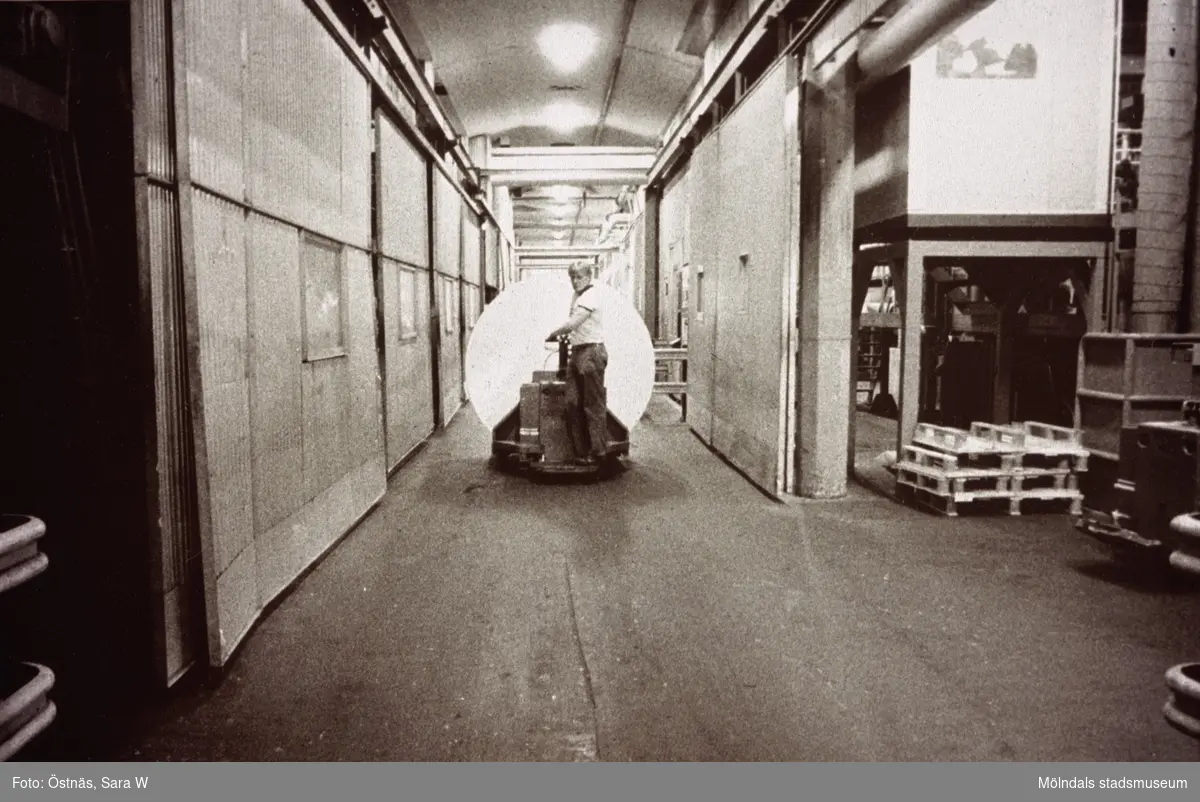 Gunnar Sandström transporterar en kartongrulle med hjälp av truck på Papyrus i Mölndal, år 1990.