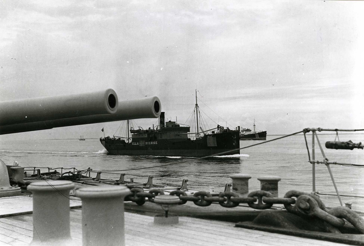 Svenska handelsfartyg i konvoj. I förgrunden däcket på en pansarkryssare under andra världskriget.