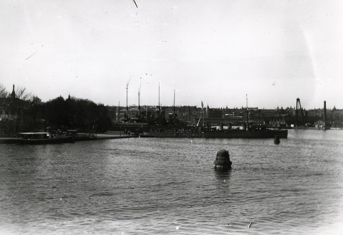 Örlogsfartyg förtöjda vid Skeppsholmens östra sida. I bakgrunden Galärvarvet och Strandvägen.
