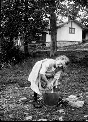 Jente vasker klær i bøtte, Heramb, Ringsaker.