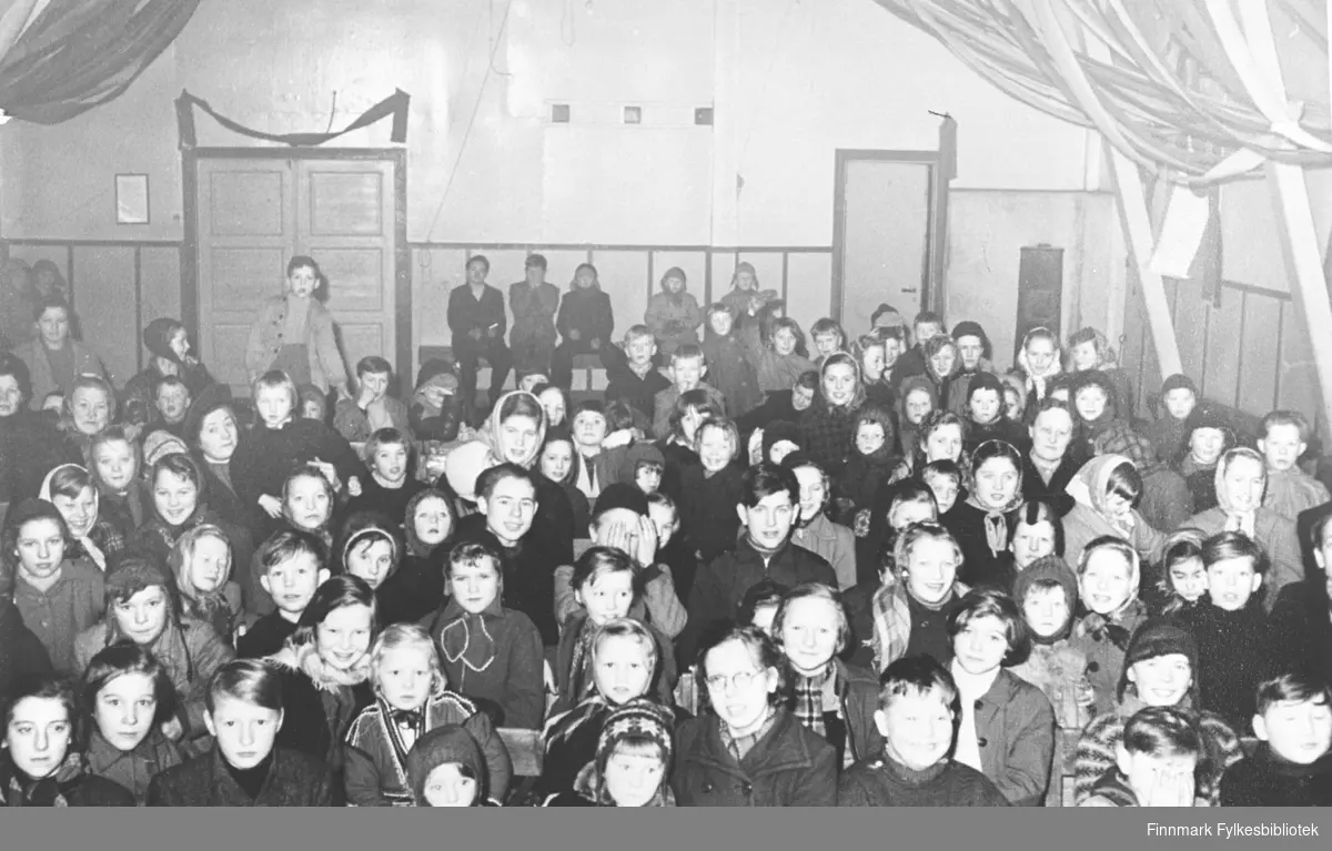 Bildet er tatt av pubikum som ser barneforestilling på Berlevåg samfunnsbrakke 1953.  Se egen navneliste.