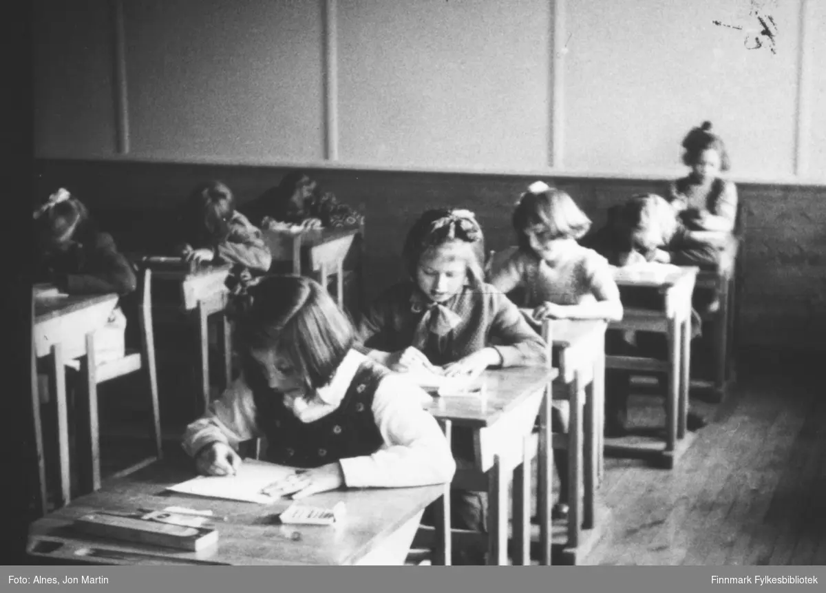 I klasserommet til 3. klasse ved Øksfjord barneskole, 1953. Elevene sitter og jobber ved pultene sin