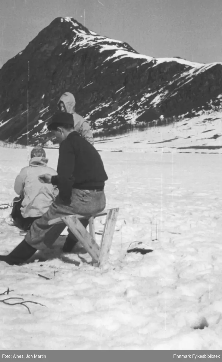 Magnus Wilhelmsen sr. (litt usikkert om det er ham) på isfiske på Vassdalsvannet i Øksfjord, våren 1955