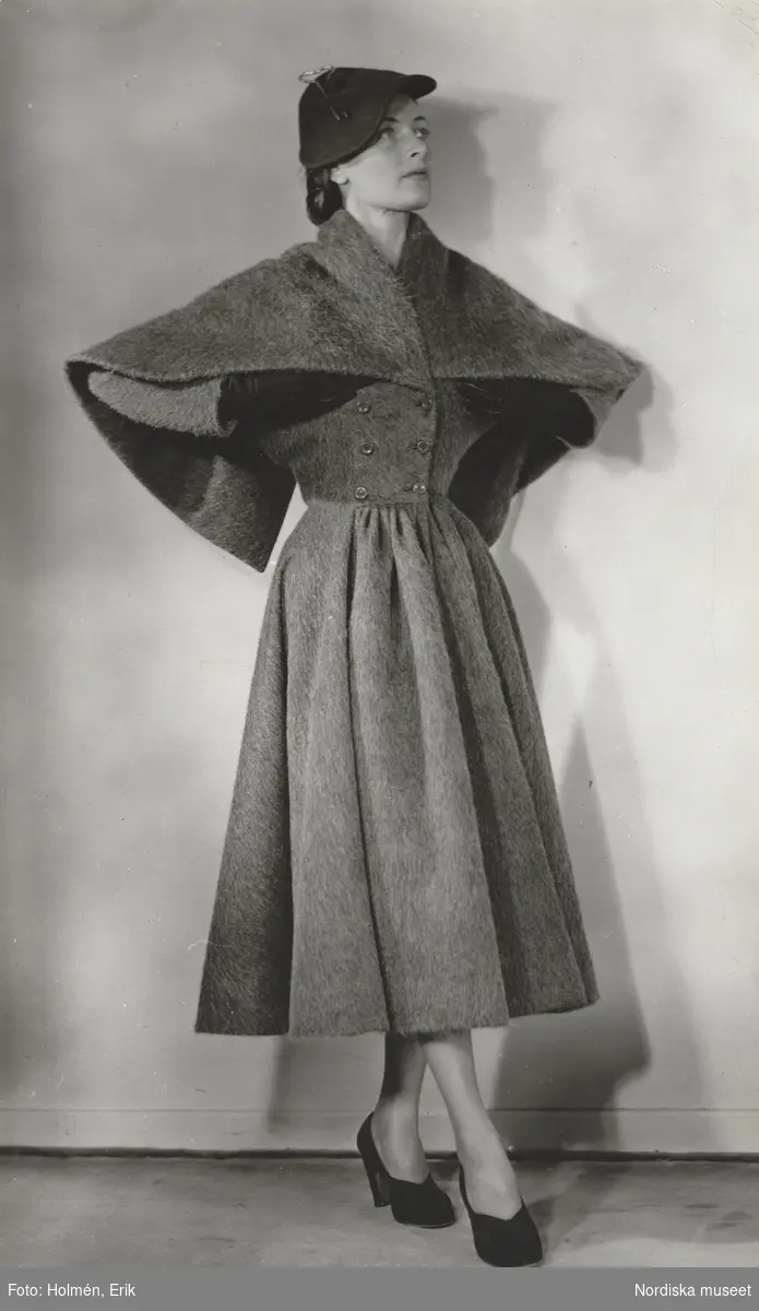 Modell i mörkgrå pälskappa med sjal, samt hatt och handskar. Madame Grès.